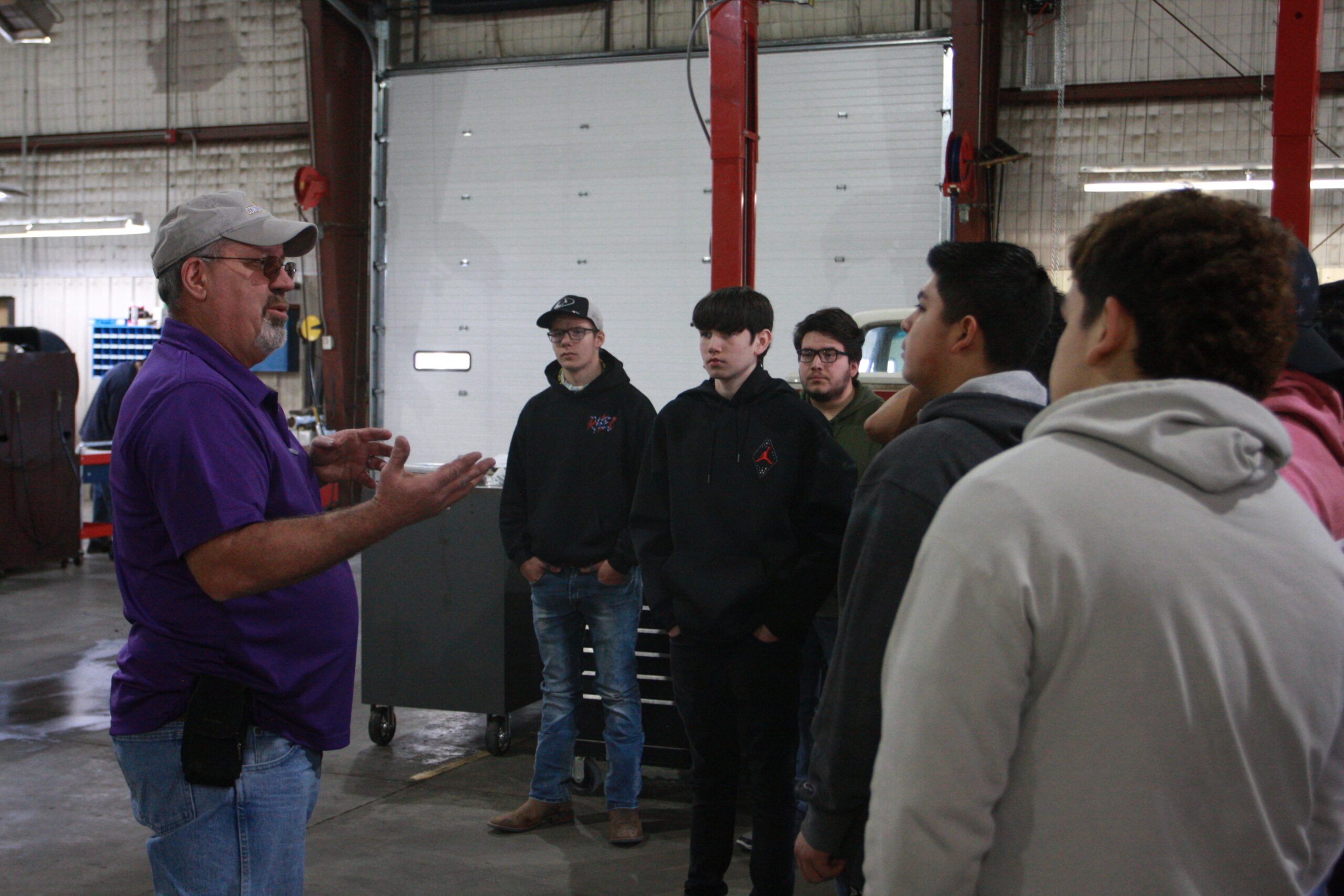 Students from Dodge City High School listening to Jeff Cole,  professor of diesel technology on ag & diesel day
